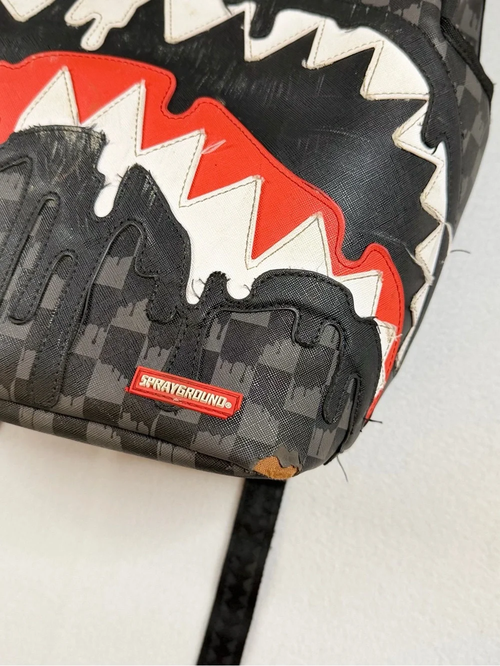 Sprayground Black Checkered Backpack with White and Red Shark Graphic